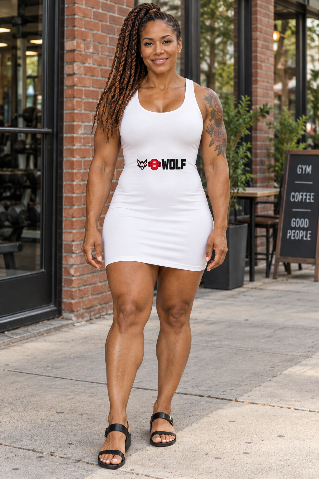 AI-generated original adult tattooed female strength athlete wearing W8WOLF Essentials Cotton Bodycon Dress in an urban setting. Actual white sleeveless scoop neck construction and centered wolf red barbell8 WOLF print retained. Sandals styling only.