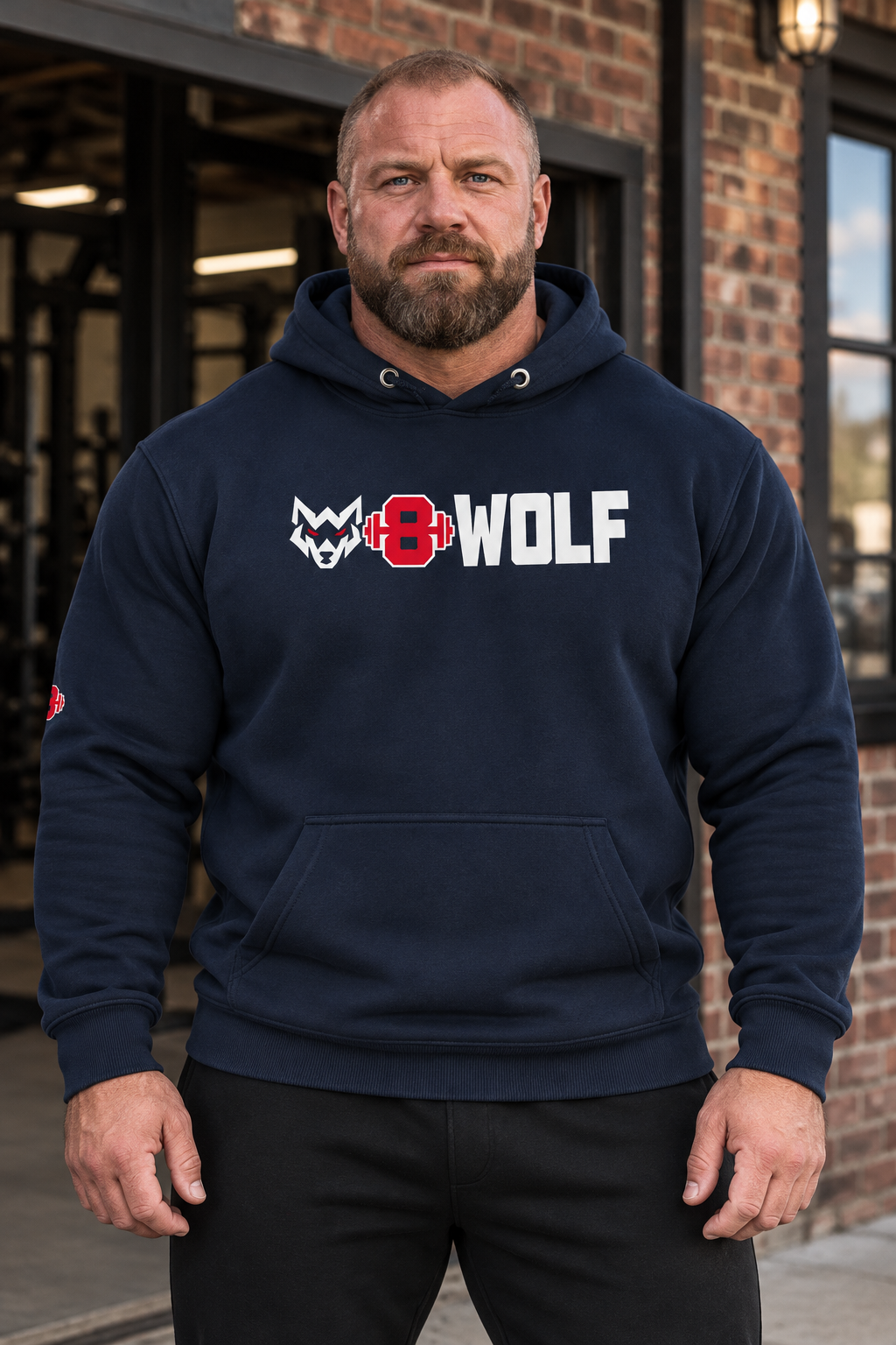 AI-generated original adult strongman wearing Navy Blazer W8WOLF Bold Logo Hoodie in an urban gym setting. Actual pullover construction original white wolf red eyes red barbell8 WOLF chest and visible sleeve mark retained. Pants styling only; other color supplier images preserved.