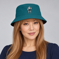 AI-generated original adult model visualization wearing teal side of W8WOLF Iron Curl Reversible Bucket Hat with original red-eyed curl wolf; original supplier front, wordmark back and distinct black reverse views retained.