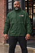 AI-generated original adult male strongman wearing Forest Green W8WOLF Essentials Windbreaker at an urban gym entrance. Actual nylon construction and small original white wolf red barbell8 WOLF left chest mark retained. Black joggers styling only; other color supplier images retained.