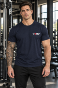 AI-generated original adult tattooed male bodybuilder wearing Navy W8WOLF Essentials Lightweight Training Tee in an urban strength gym. Actual small original white wolf red eyes red barbell8 WOLF left chest mark retained. Pants styling only; Black variants preserved.
