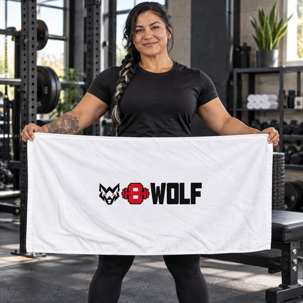 AI-generated original adult tattooed female powerlifter displaying W8WOLF Bold Logo Gym Shower Towel 30 by 60 inches in an urban gym. Actual white rectangular towel and centered black wolf red eyes red barbell8 WOLF design retained. Clothing styling only.