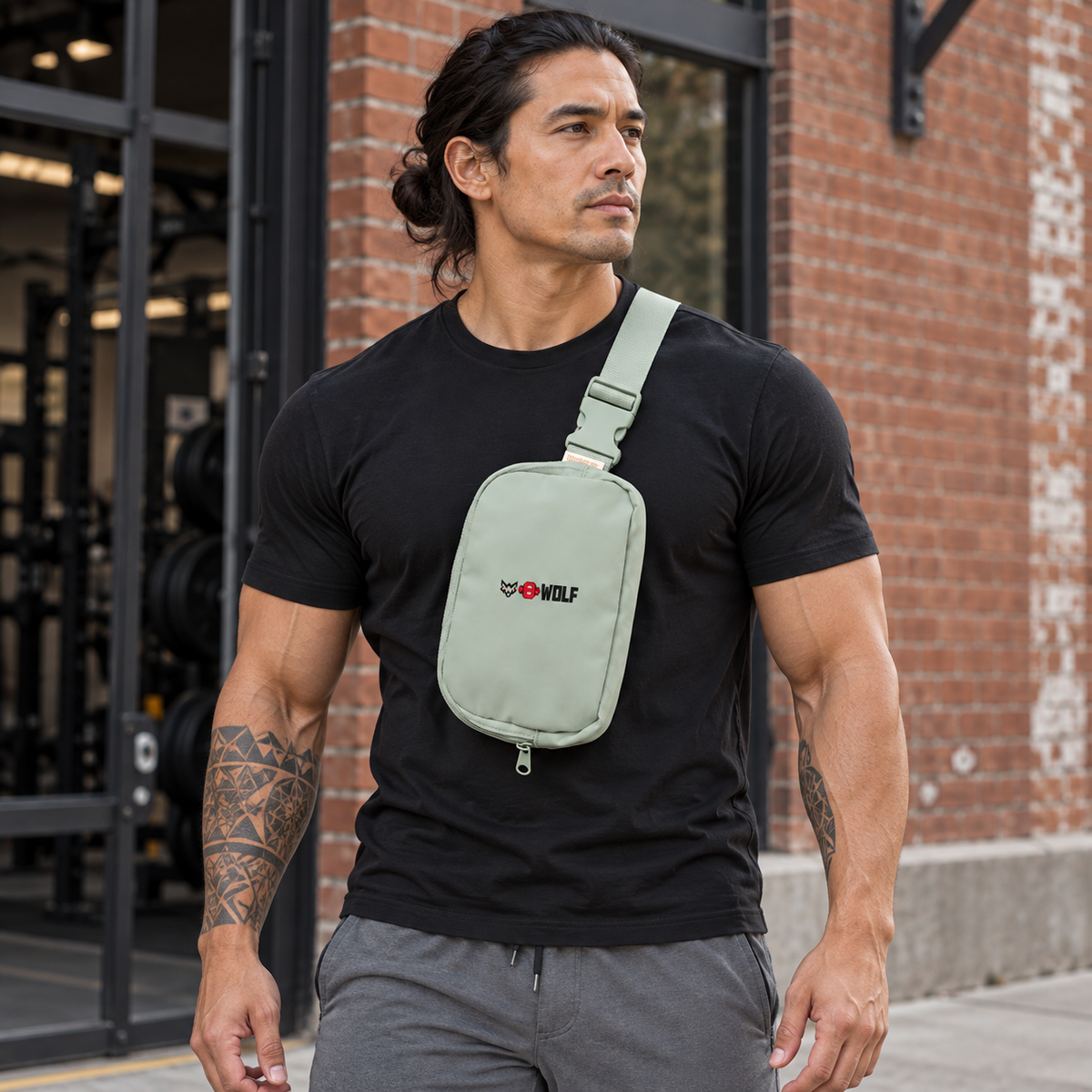 AI-generated original adult tattooed male powerlifter wearing Bay W8WOLF Gym Sling Bag in an urban gym setting. Actual pale sage fabric matching strap buckle and small original wolf red barbell8 WOLF logo retained. Clothing styling only. Other colors remain excluded; supplier images retained.